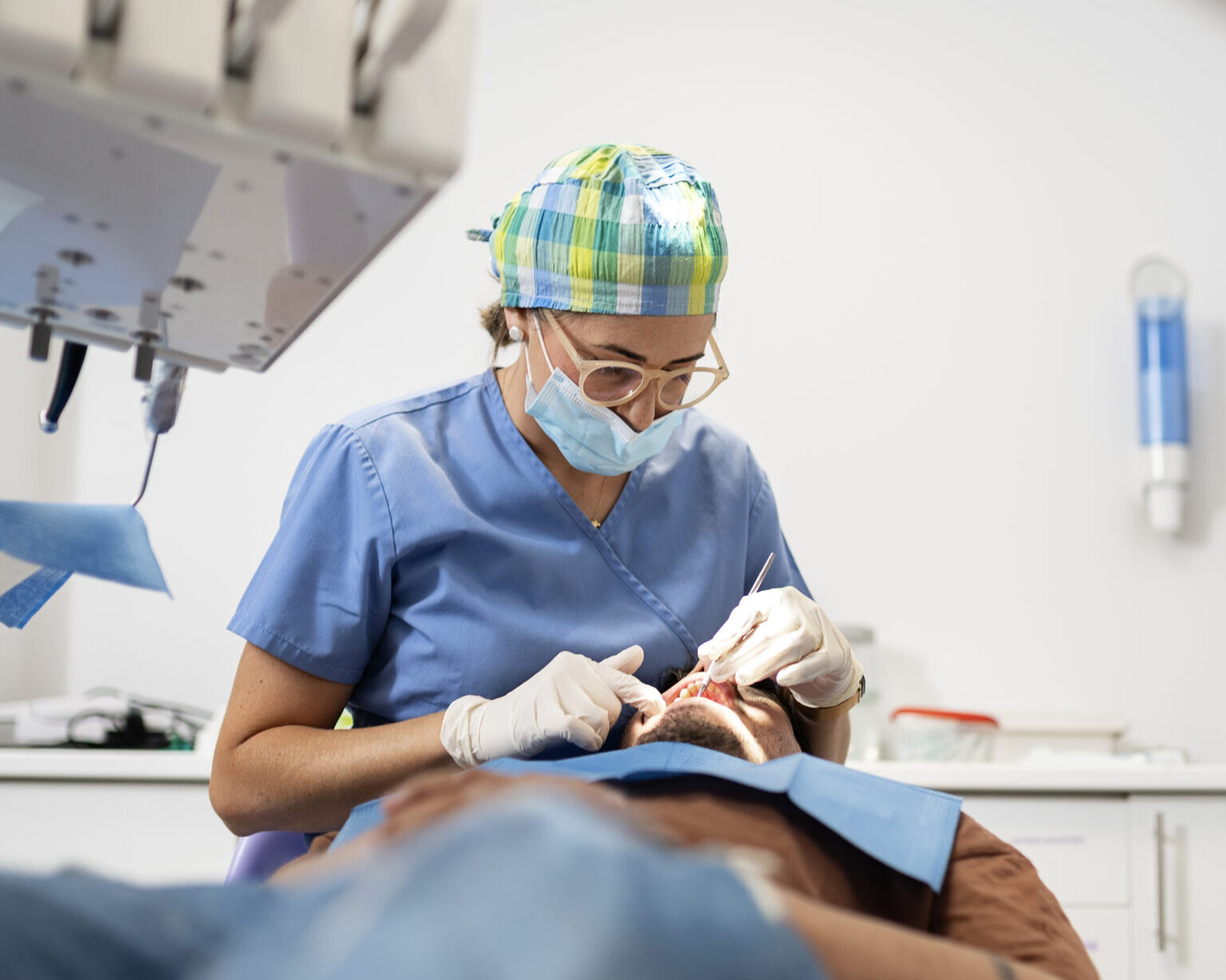 dentist performing oral checkup on patient in dental clinic